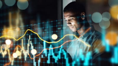 Businessman using a digital tablet with a graphical chart, symbolising the stock market.